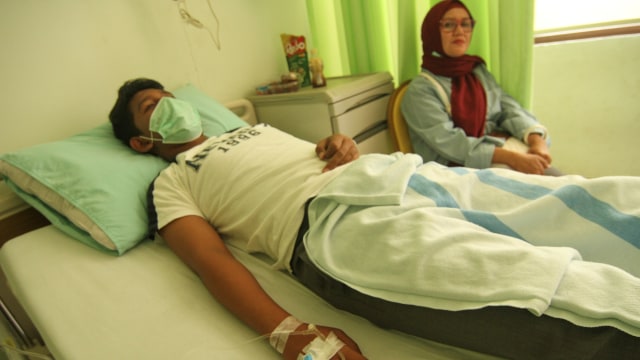 Pasien bernama Fandri (kiri) siswa kelas 3 SMPN 20 Depok penderita Hepatitis A menjalani rawat inap di RSUD Depok, Jawa Barat, Jumat (22/11/2019). Foto: ANTARA FOTO/Asprilla Dwi Adha