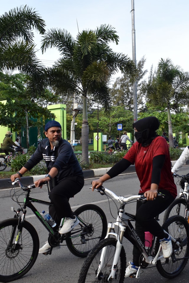 Warga mendayung sepeda melewati kuburan massal tsunami di Ulee Lheu. Foto: Adi Warsidi/acehkini