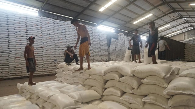 Pekerja mengangkut karung berisi beras di Gudang Perum Bulog, Jakarta. Foto: Iqbal Firdaus/kumparan
