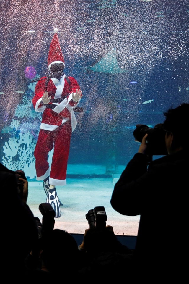 Seorang penyelam yang berpakaian seperti Sinterklas melambai kepada penonton saat pertunjukan promosi Natal di Seoul, Korea Selatan (4/12). Foto: REUTERS / Kim Hong-Ji