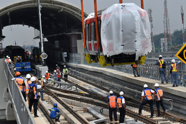 Petugas mengawasi proses pengangkatan gerbong kereta lintas rel terpadu (LRT) ke atas rel di Stasiun Harjamukti, Cimanggis, Depok, Rabu (4/12). Foto: ANTARA FOTO/Aditya Pradana Putra
