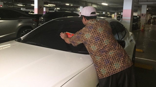 Mobil mewah yang belum bayar pajak dipasang stiker objek pajak oleh BPRD Jakarta dengan supervisi KPK. Foto: Lutfan Darmawan/kumparan
