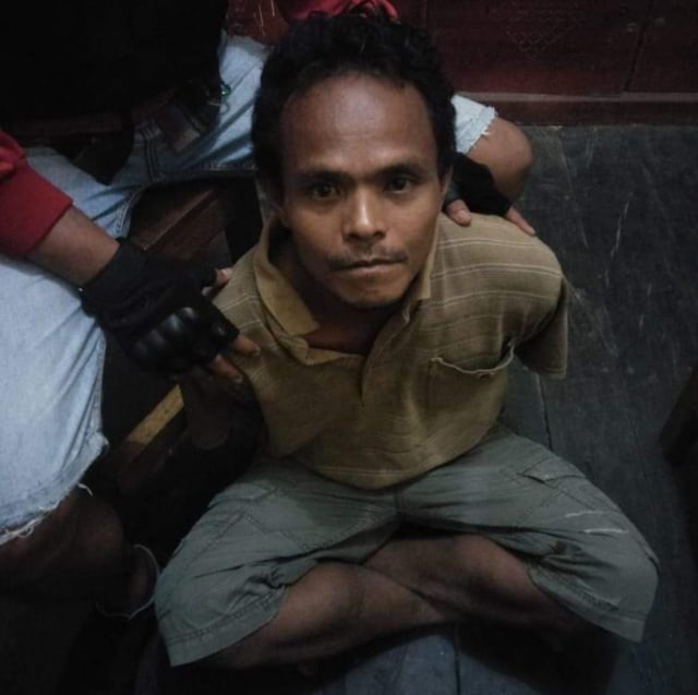 A(35),pelaku pemenggalan kepala anak SD di Kalteng saat diamankan oleh petugas kepolisian Polres Katingan.(Warga For InfPBUN) 