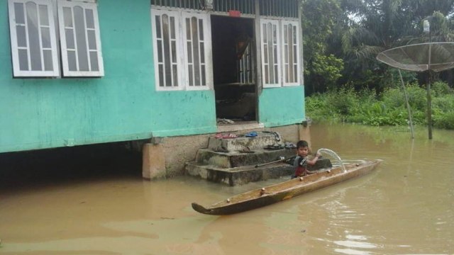 SEORANG anak laki-laki sedang menimba air yang masuk ke sampannya di depan halaman rumahnya, Senin, 9 Desember 2019, Kecamatan Kuantan Hilir, Kabupaten Kuantan Singingi (Kuansing), Riau. 