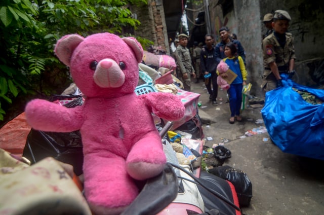 Seorang anak membawa boneka miliknya saat penggusuran permukiman Tamansari di Bandung, Jawa Barat, Kamis (12/12/2019). Foto: ANTARA FOTO/Raisan Al Farisi