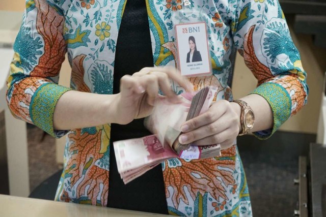Petugas teller PT Bank Negara Indonesia (Persero) Tbk atau BNI sedang menghitung uang sebanyak lima puluh juta rupiah di Jakarta pada Kamis, (19/12). Foto: Dok. BNI