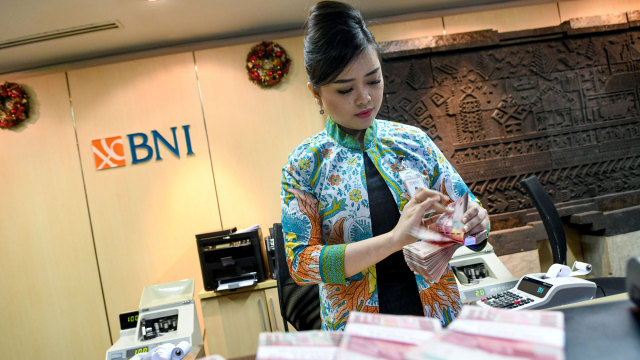 Seorang teller PT Bank Negara Indonesia (Persero) Tbk menghitung uang pecahan Rp100 ribu di Kantor Pusat BNI, Jakarta, Kamis (19/12/2019). Foto: ANTARA FOTO/M Risyal Hidayat