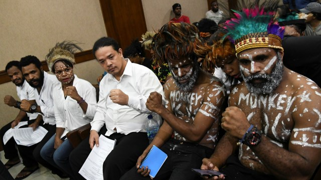(Dari kiri) Terdakwa makar Issay Wenda, Charles Kossay, Arina Elopere, Surya Anta, Ambrosius Mulait dan Dano Tabuni mengepalkan tangan saat menunggu sidang. Foto: ANTARA FOTO/Nova Wahyudi