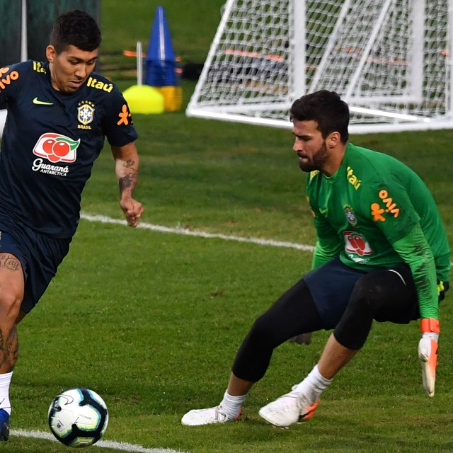 Roberto Firmino dan Alisson Becker saat memperkuat Timnas Brasil. Foto: KARIM JAAFAR / AFP