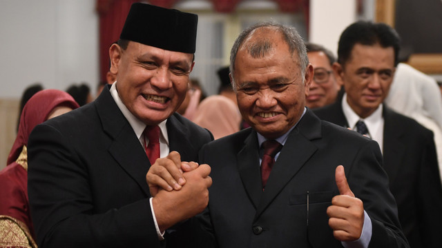 Ketua KPK Firli Bahuri (kiri) berjabat tangan dengan Agus Rahardjo usai pelantikan di Istana Negara, Jakarta. Foto: ANTARA FOTO/Akbar Nugroho Gumay