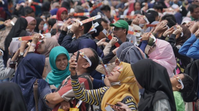 Pengunjung menggunakan kacamata khusus melihat proses gerhana matahari cincin di Planetarium Taman Ismail Marzuki, Jakarta, Kamis (26/12). Foto: Helmi Afandi Abdullah/kumparan 