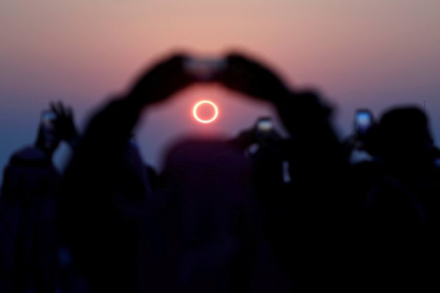 Warga mengambil foto proses terjadinya gerhana matahari cincin di Hofuf, Arab Saudi.  Foto: REUTERS / Hamad I Mohammed