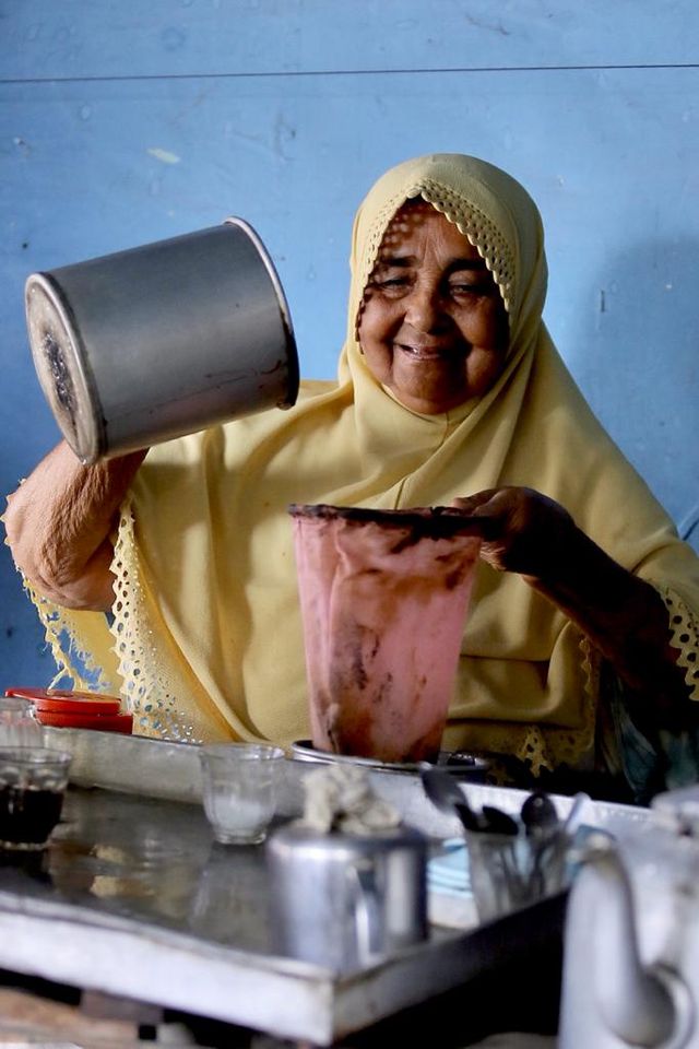 Nek Fatimah menyaring kopi di warung kopi tradisional miliknya di Blang Dhot, Tangse, Rabu (25/12). Foto: Abdul Hadi/acehkini