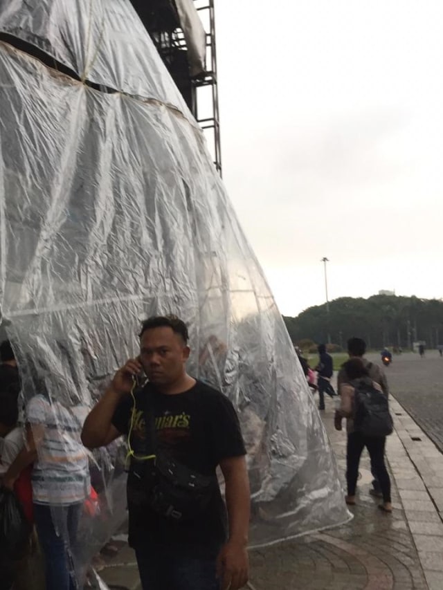 Hujan mengguyur jelang malam pergantian tahun di Monumen Nasional (Monas), Jakarta, Selasa (31/12).  Foto: Muhammad Darisman/kumparan 