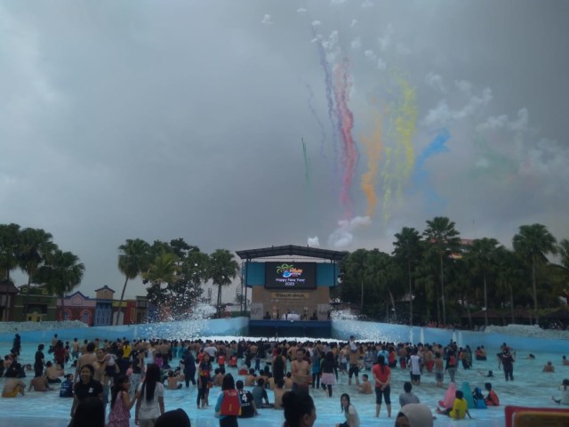 Serunya selebrasi Smoke Bomb Party, bom asap aneka warna yang meluncur ke udara di tempat wisata Hawai Waterpark Malang, Rabu (1/1/2020). (Foto: Khusnul Hasana/Tugumalang.id)