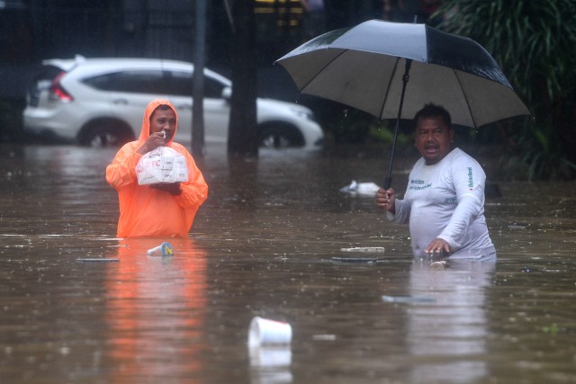 Kurir pengantar makanan melintasi Jalan Kemang Raya yang terendam banjir Jakarta Selatan, Rabu (1/1). Foto: ANTARA FOTO/Sigid Kurniawan