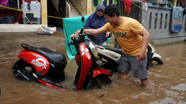 Warga Cipinang Melayu memindahkan kendaraan mereka, Kamis (2/1). Foto: Irfan Adi Saputra/kumparan