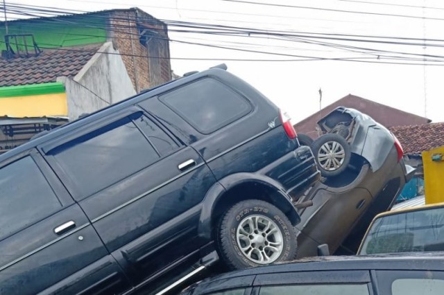 Sejumlah kendaraan terseret arus kemudian tertumpuk di dekat akses masuk Komplek Perumahan Pondok Gede Permai, Kecamatan Jatiasih, Kota Bekasi. Foto: ANTARA/Sri Muryono