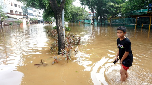 Seorang anak bermain di genangan banjir di Jalan Bungur Raya, Jakarta Pusat, Kamis (2/1).
Foto: Nugroho Sejati/kumparan