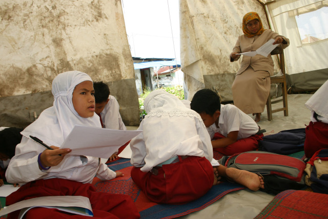 Sejumlah siswa di Kampung Mulia, Banda Aceh belajar di tenda setelah sekolah mereka dihancurkan tsunami. Foto diambil 2 Januari 2006. Foto: Adi Warsidi