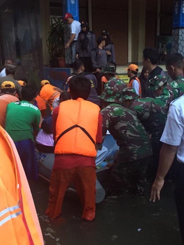 Seorang warga yang sakit dievakuasi dengan perahu karet bersama rombongan Anies Baswedan. Foto: Efira Tamara Thenu/kumparan