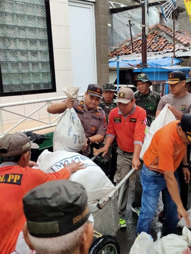 Personel TNI dan Polri dibantu pasukan oranye bersihkan rumah warga di Grogol, Jakarta Barat. Foto: Mirsan Simamora/kumparan 