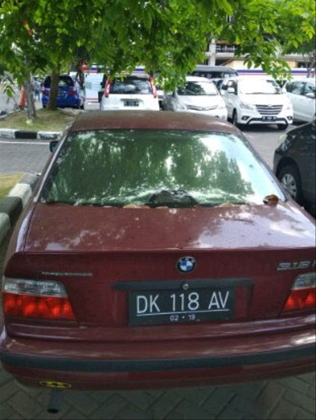 mobil BMW merah dengan plat DK 1 dengan plat DK 118 AV yang terparkir di area parkir terminal domestik Bandara I Gusti Ngurah Rai sejak 22 September 2016 lalu. Foto: Dok. Istimewa