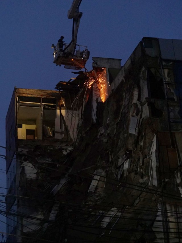 Petugas berusaha memotong beton bagian atas gedung yang roboh, di Slipi, Jakarta Barat, Senin (6/1). Foto: Jamal Ramadhan/kumparan