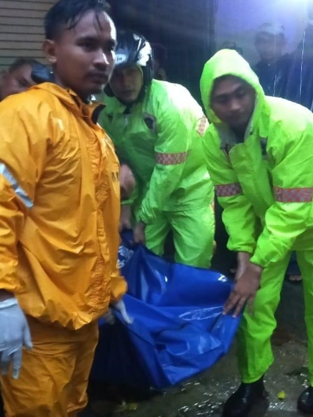Petugas mengevakuasi pasutri yang tewas tertimpa pohon di Surabaya, Senin (6/1). Foto: Dok. Istimewa