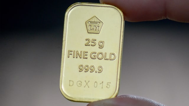 Warga menunjukkan emas batangan 25 gram sebelum dijual di Butik Emas Logam Mulia Antam. Foto: ANTARA FOTO/Raisan Al Farisi