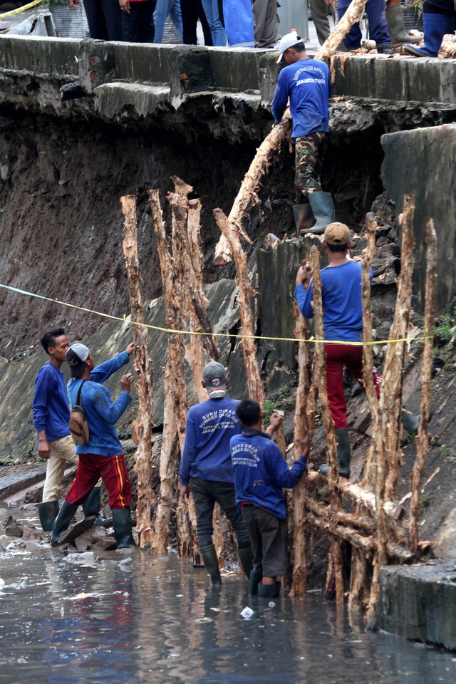 Proses perbaikan turap Kali Sunter yang amblas di Jalan Cinta, Pulogadung, Jakarta Timur, Sabtu (11/1). Foto: Iqbal Firdaus/kumparan