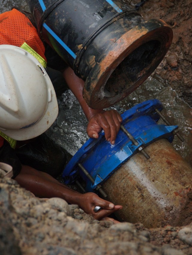 Petugas memperbaiki pipa PDAM di jalan yang amblas di Daan Mogot, Tangerang, Senin (14/1/2020). Foto: Jamal Ramadhan/kumparan