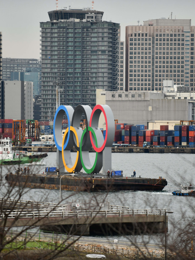 Sebuah kapal tongkang membawa simbol Olimpiade berukuran raksasa di perairan Taman Laut Odaiba, Tokyo, Jepang, Jumat (17/1). Foto: Kazuhiro NOGI / AFP