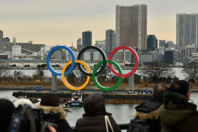 Sebuah kapal tongkang membawa simbol Olimpiade berukuran raksasa di perairan Taman Laut Odaiba, Tokyo, Jepang, Jumat (17/1). Foto: Kazuhiro NOGI / AFP