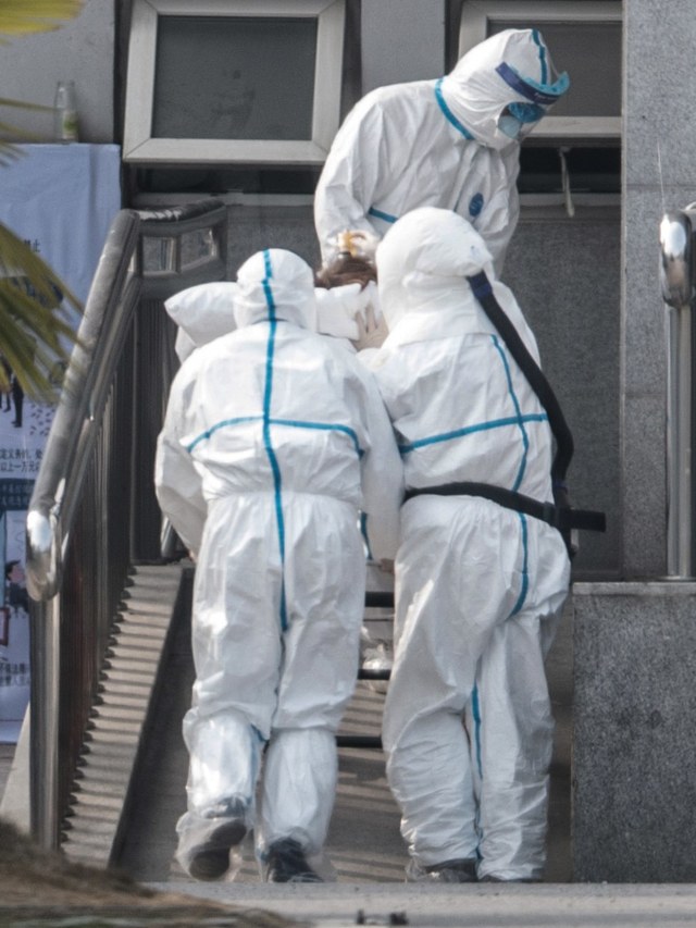 Petugas medis membawa seorang pasien yang diduga terkena virus Wuhan ke rumah sakit Jinyintan, China.  Foto: AFP/STR