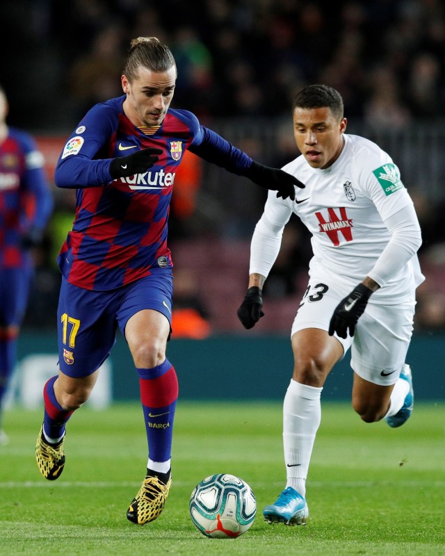 Pemain Barcelona, Antoine Griezmann, berduel dengan pemain lawan. Foto: REUTERS/Albert Gea