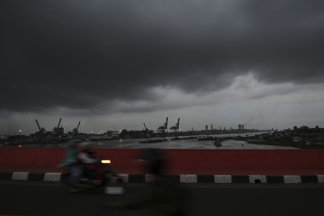 Pengendara melintas diatas jembatan musi IV dengan latar belakang awan hitam yang menyelimuti langit Palembang, Sumatera Selatan, Selasa (21/1). Foto: ANTARA FOTO/Nova Wahyudi