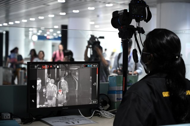 Petugas kesehatan Malaysia menggunakan 'thermal scanner' mendeteksi suhu tubuh penumpang yang tiba di Bandara Internasional Kuala Lumpur, Malaysia. Foto: AFP/MOHD RASFAN