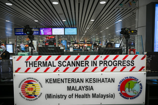 Petugas kesehatan Malaysia menggunakan 'thermal scanner' mendeteksi suhu tubuh penumpang yang tiba di Bandara Internasional Kuala Lumpur, Malaysia. Foto: AFP/MOHD RASFAN 
