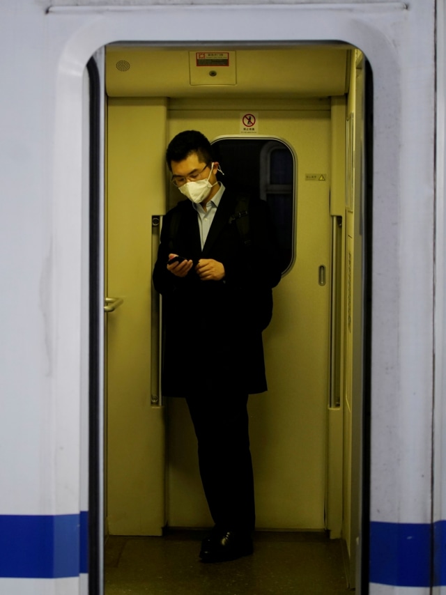 Penumpang kereta api memakai masker di stasiun kereta api Shanghai di Shanghai, China, Rabu (22/1). Foto: REUTERS/Aly Song