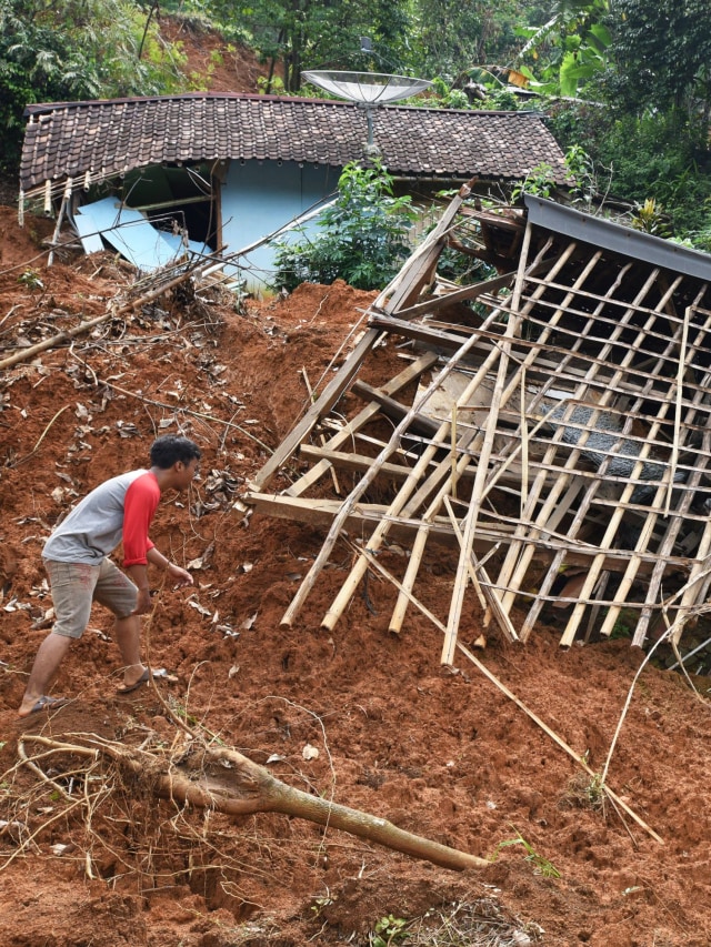 Warga melihat puing rumahnya yang rusak tertimbun longsor di Kampung Cigobang, Banjarsari, Lebak, Banten, Kamis (23/1).  Foto: ANTARA FOTO/Asep Fathulrahman