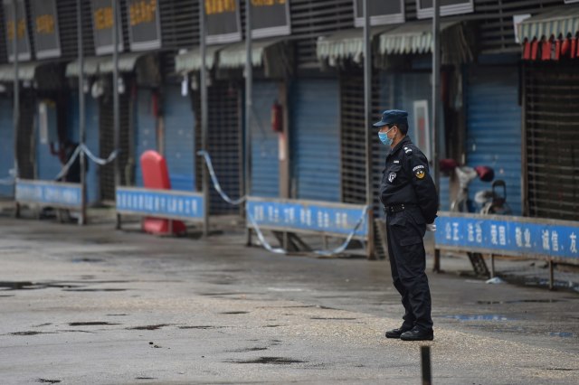 Petugas keamanan berjaga di sekitar Pasar Makanan Laut Huanan lokasi terdeksi Virus Corona di Wuhan, Hubei, China.
 Foto: AFP/HECTOR RETAMAL