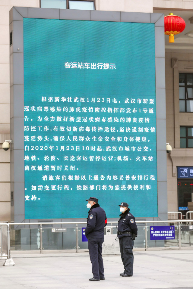 Polisi berjaga di dekat pengumuman penutupan Stasiun Kereta Api Hankou di Wuhan, Hubei, China. Foto: Chinatopix via AP