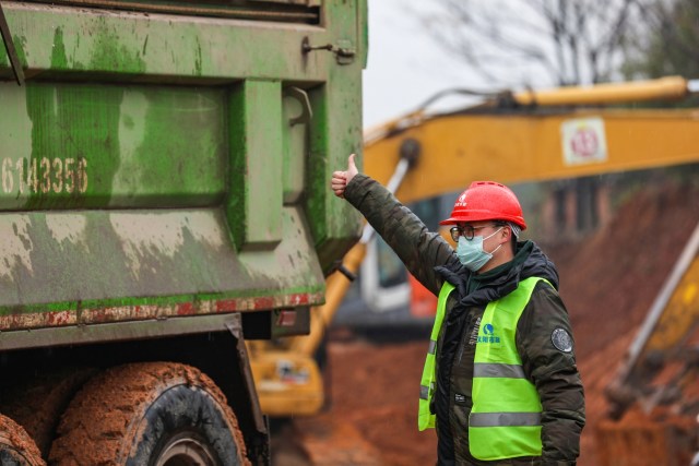 Seorang pekerja menggunakan masker di lokasi pembangunan rumah sakit untuk merawat pasien selama wabah virus di Wuhan, China. Foto: APF/STR