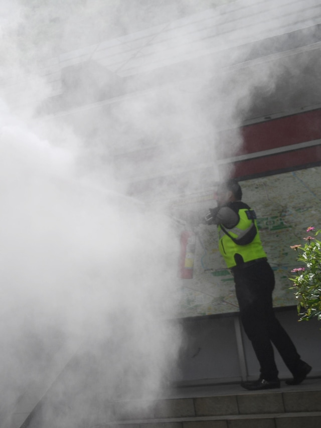 Anggota polisi berusaha memadamkan api yang membakar gardu listrik di samping Pos Polisi Bundaran HI, Jakarta, Senin (27/1/2020). Foto: ANTARA FOTO/Akbar Nugroho Gumay