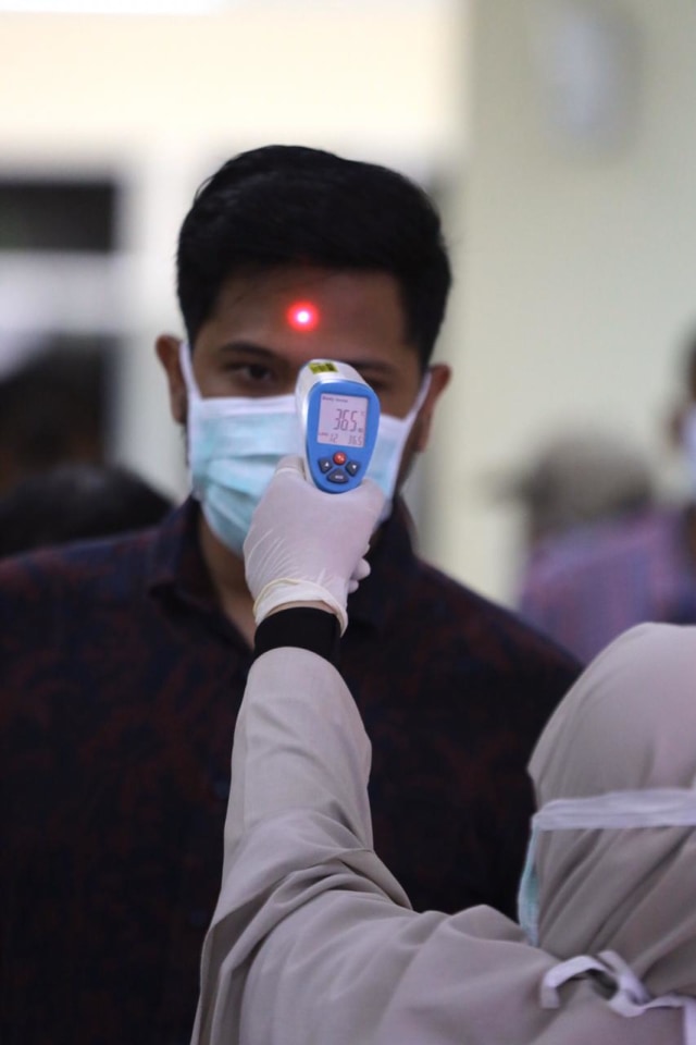 Petugas melakukan screening terhadap penumpang yang baru tiba dari luar negeri di Bandar Udara Sultan Iskandar Muda, Aceh, Selasa (28/1). Foto: Suparta/acehkini 