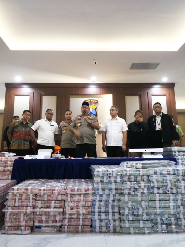 Kapolda Jawa Timur Irjen Pol Luki Hermawan (tengah) menunjukkan barang bukti uang investasi ilegal di Polda Jawa Timur, Surabaya, Jawa Timur, Jumat (10/1).  Foto: ANTARA FOTO/Didik Suhartono