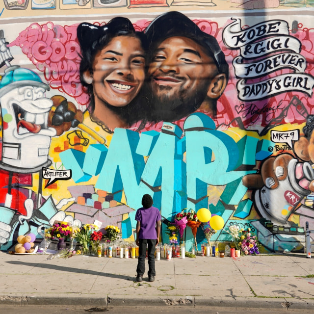 Penggemar menatap mural dengan wajah Kobe Bryant dan putrinya Gianna di Microsoft Square, Los Angeles. Foto: REUTERS/Kyle Grillot