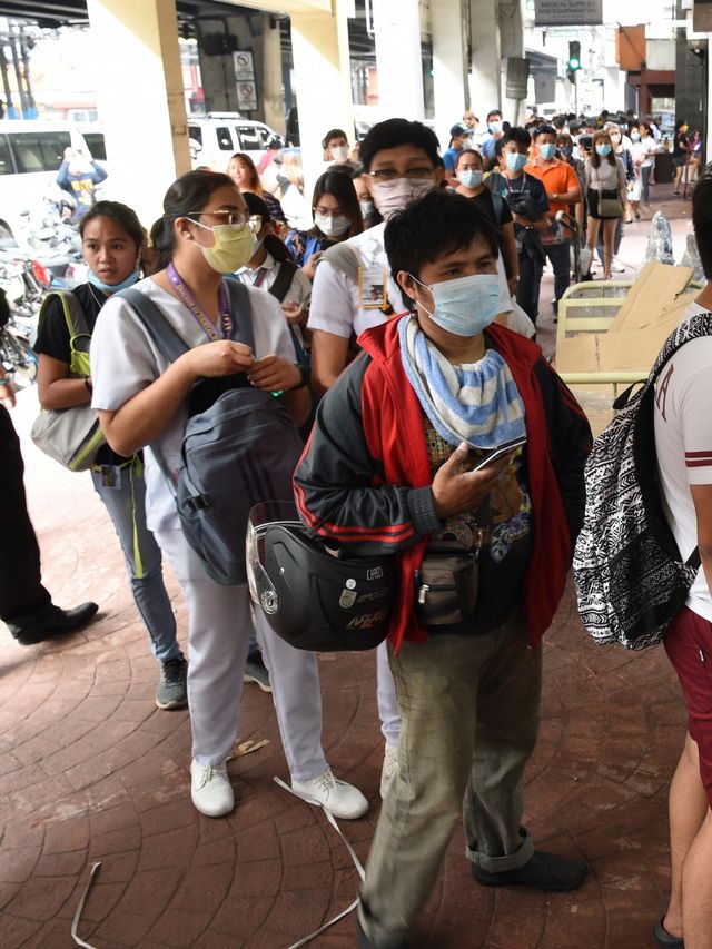 Warga mengantre untuk mendapatkan masker di Manila, Filipina. Foto: AFP/TED ALJIBE