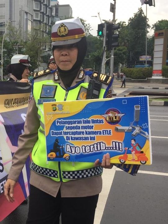 Polwan dari Ditlantas Polda Metro Jaya melakukan sosialisasi penilangan dengan kamera CCTV atau ETLE untuk motor di Jalan MH Thamrin, Jakarta Pusat. Foto: Raga Imam/kumparan